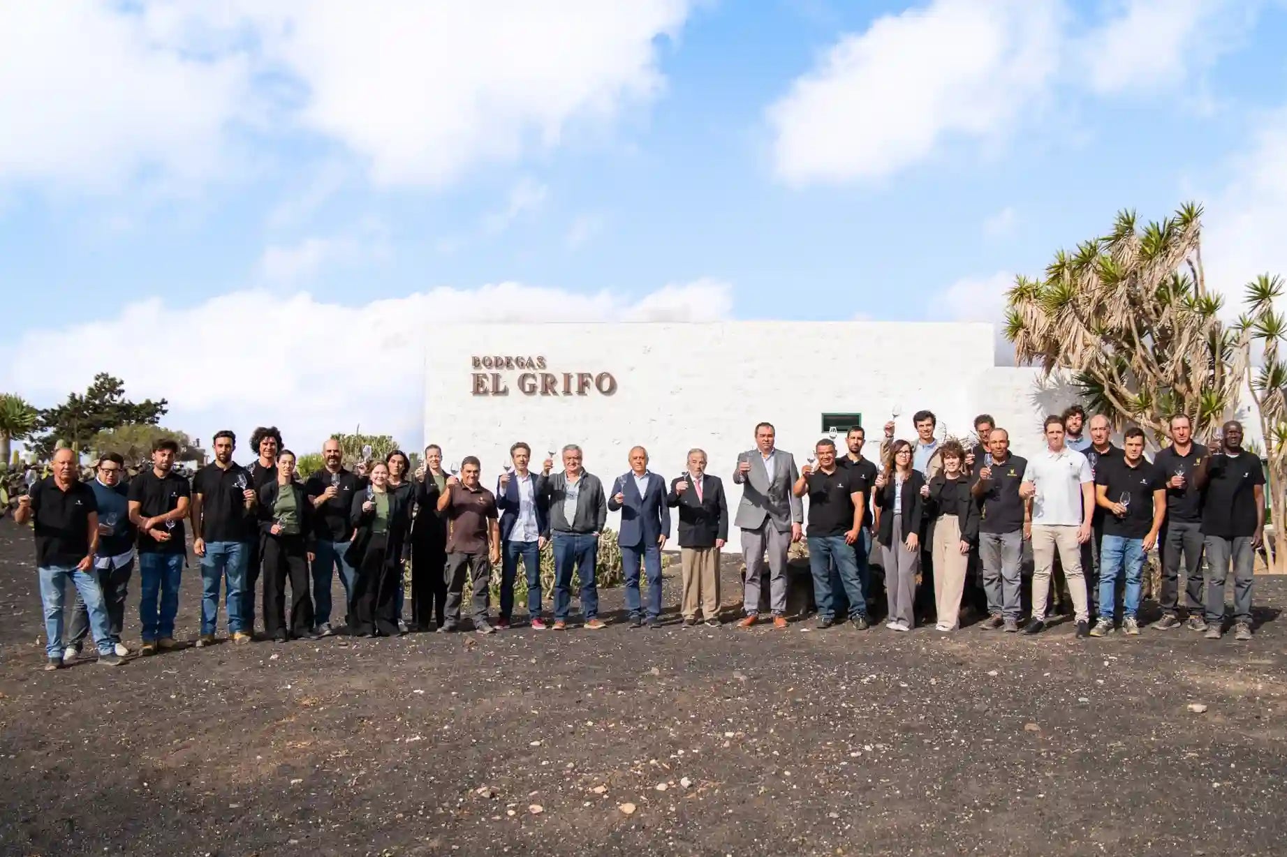 Equipo de Bodegas El Grifo posando frente a la fachada