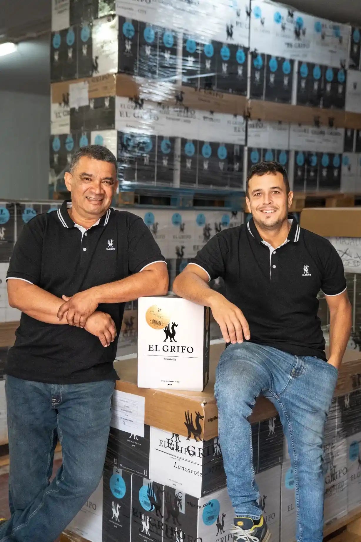 El equipo logístico de la bodega sonríen junto a cajas de vino listas para su distribución, representando el cuidado en cada etapa del proceso.